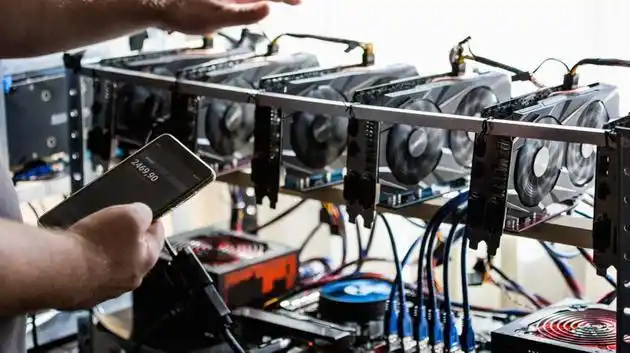 A person examining the internal components of a mining rig, highlighting the technical aspect.